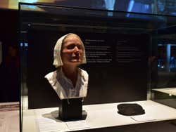 A sculpture of a woman's head in a museum