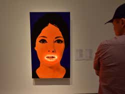 A painting of a woman with an orange face